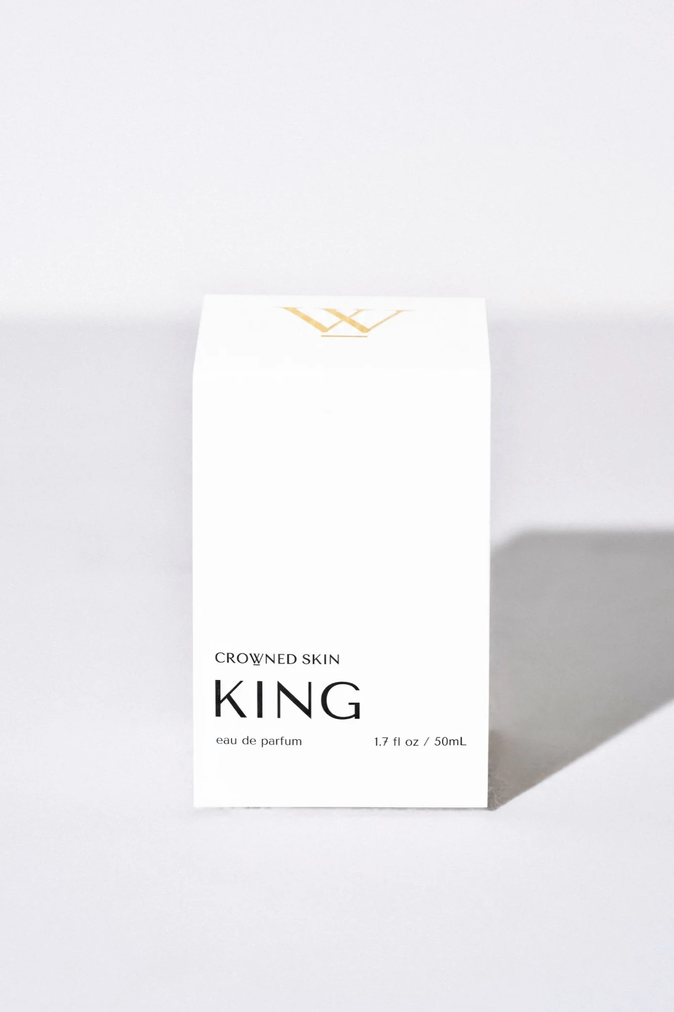 Crowned Skin King Eau de Parfum bottle displayed elegantly — a luxury men's fragrance featuring notes of Mandarin, Patchouli, Dark Vanilla, and Musk.