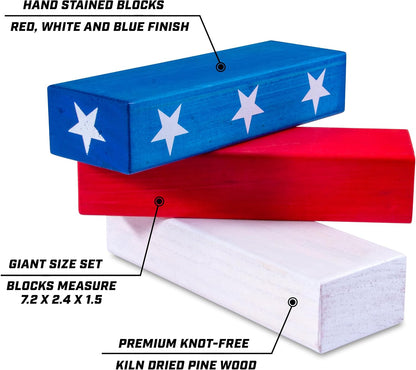 GoSports Giant Wooden Toppling Tower stacking game in Stars and Stripes edition standing over 5 feet tall outdoors at a 4th of July backyard party