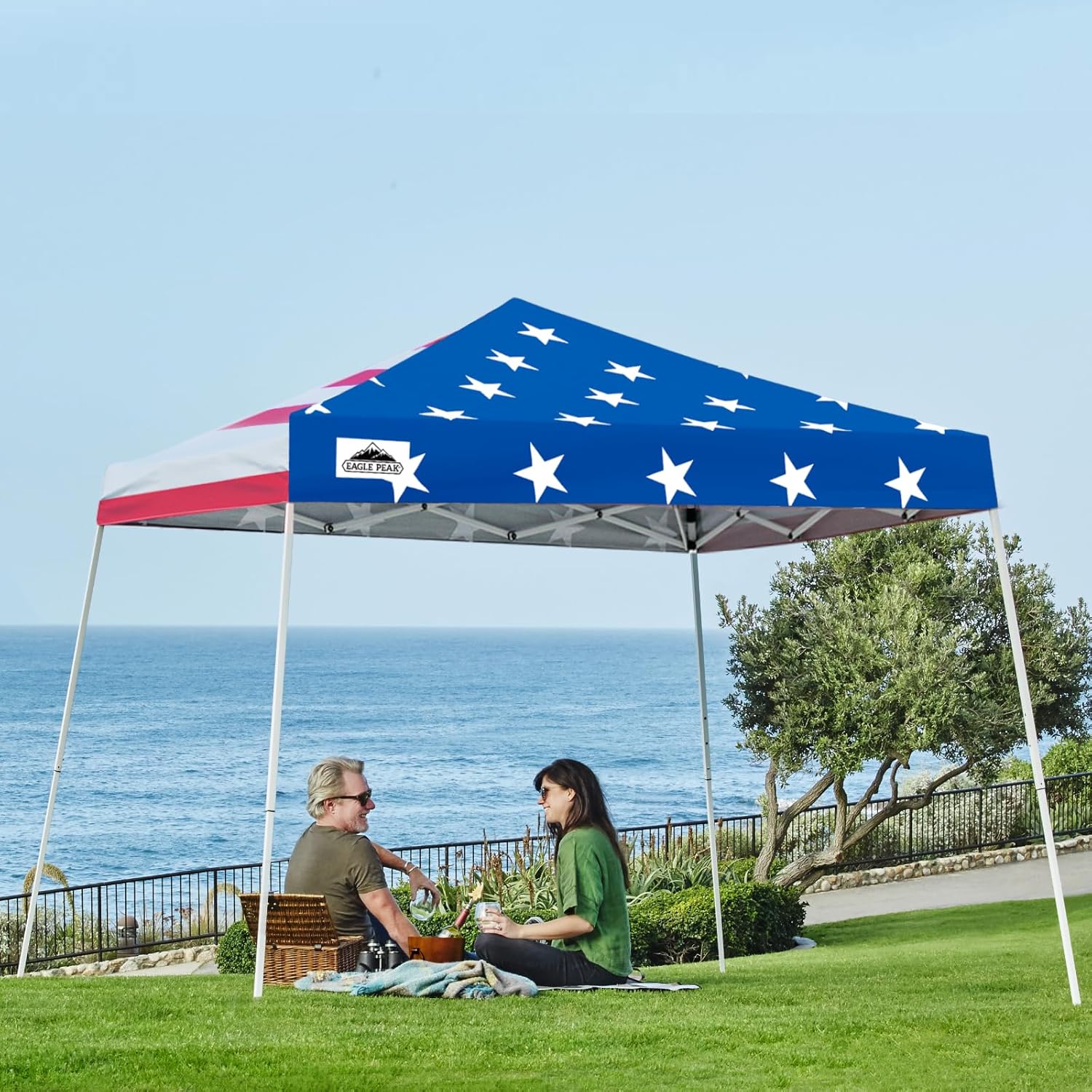 Eagle Peak 10x10 American Flag slant leg pop-up canopy tent set up outdoors with bold patriotic red white and blue design