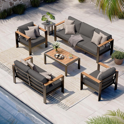 Oasbira 5-piece aluminum patio furniture set in graphite with thick cushioned sectional sofa and coffee table set up on backyard deck