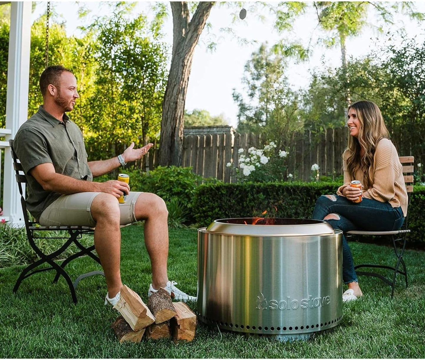 Solo Stove Yukon 2.0 stainless steel smokeless fire pit with stand glowing with a wood fire in a backyard at night