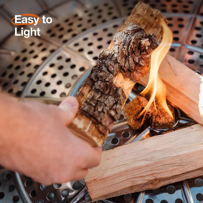 Solo Stove Yukon 2.0 stainless steel smokeless fire pit with stand glowing with a wood fire in a backyard at night