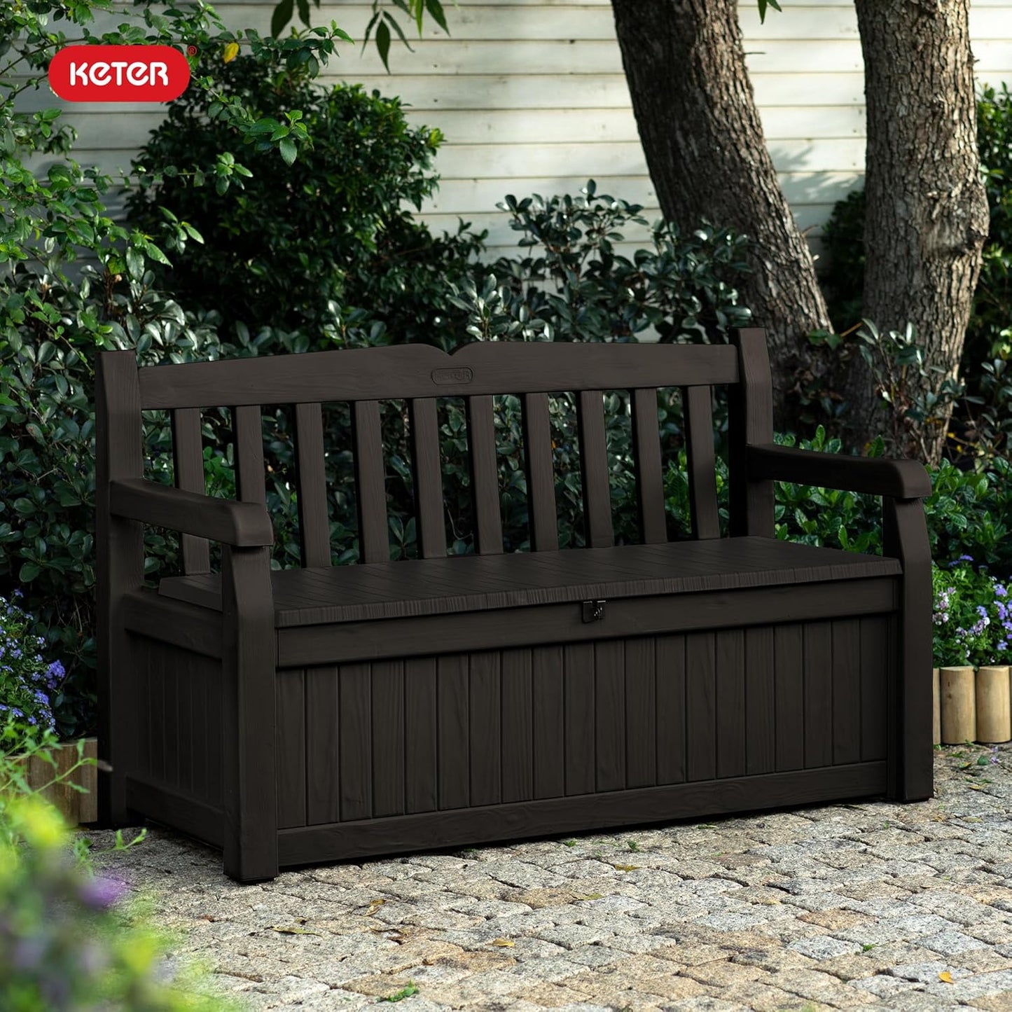 Keter Solana 70 gallon outdoor storage bench deck box in brown resin with wood texture finish on backyard patio storing cushions and pool accessories
