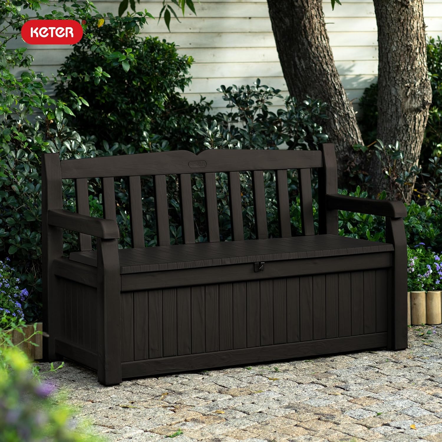 Keter Solana 70 gallon outdoor storage bench deck box in brown resin with wood texture finish on backyard patio storing cushions and pool accessories