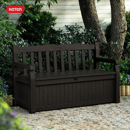 Keter Solana 70 gallon outdoor storage bench deck box in brown resin with wood texture finish on backyard patio storing cushions and pool accessories