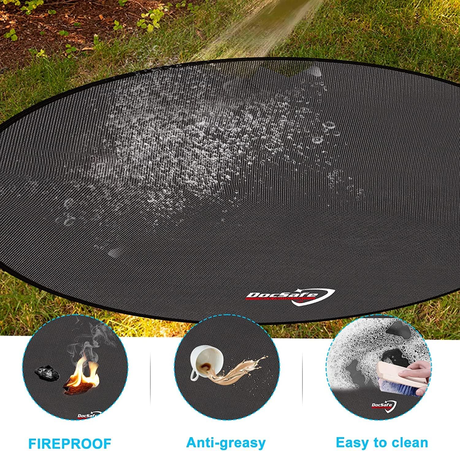 Black round 48-inch fireproof fire pit mat placed under an outdoor fire pit on a wooden deck