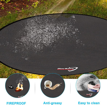 Black round 48-inch fireproof fire pit mat placed under an outdoor fire pit on a wooden deck