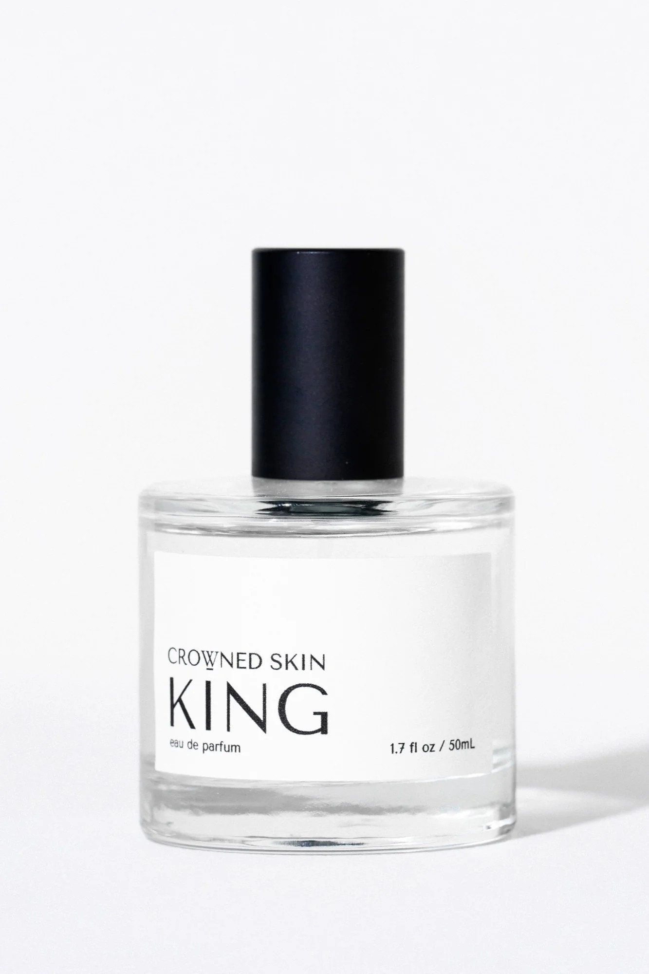 Crowned Skin King Eau de Parfum bottle displayed elegantly — a luxury men's fragrance featuring notes of Mandarin, Patchouli, Dark Vanilla, and Musk.