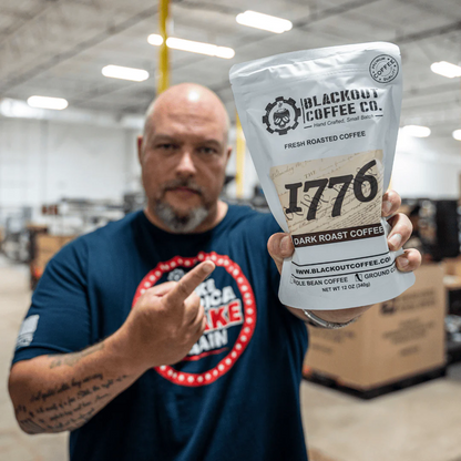 Blackout Coffee 1776 Dark Roast 12oz coffee bag on a dark surface with bold patriotic branding and American flag imagery